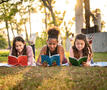 kinderen lezen een boek in het park